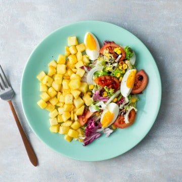 Salade met tomaat, maïs en gebakken aardappelblokjes